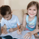 Boy and girl writing in activity book